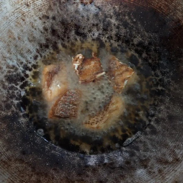 Goreng ikan kakap yang telah dilumuri garam dan jeruk nipis.