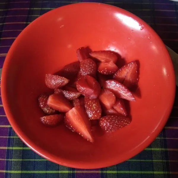 Potong buah strawberry jadi 4 bagian.