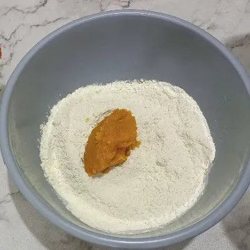 Campur terigu, gula pasir, ragi instan, susu bubuk aduk rata masukan labu kuning halus, tuang air bertahap uleni sampai setengah kalis