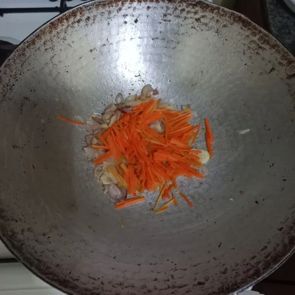 Tumis irisan bawang merah dan bawang putih hingga harum, masukkan irisan korek wortel dan air secukupnya, aduk rata.