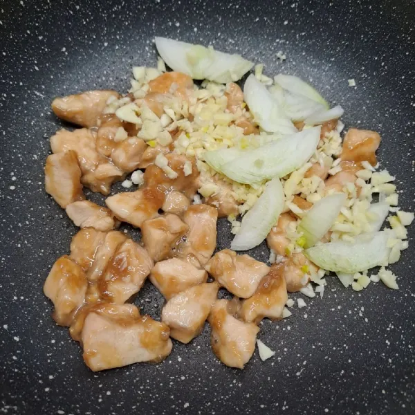 Masukkan irisan bawang bombay dan bawang putih cincang. Tumis sampai layu dan harum.
