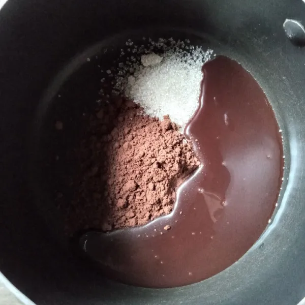 Dalam panci masukkan bubuk cokelat, gula dan kental manis, aduk rata.