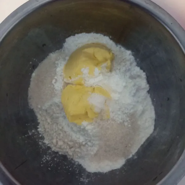 Dalam wadah masukkan semua bahan adonan tepung kecuali air, aduk hingga tercampur rata.