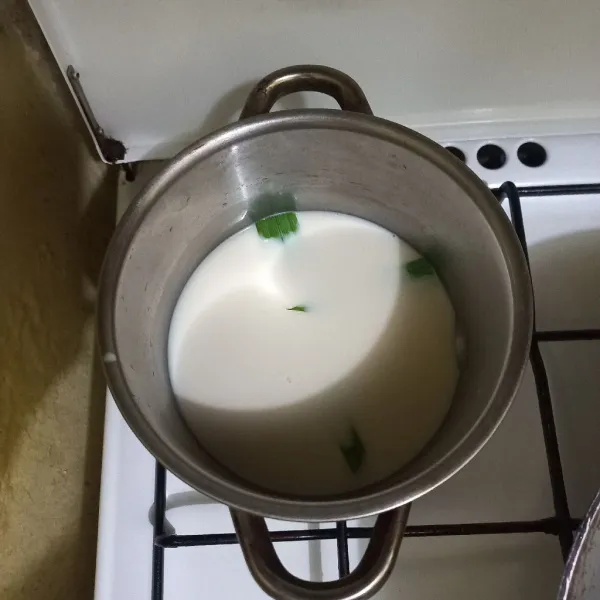 Didihkan susu cair bersama daun pandan dengan api kecil.