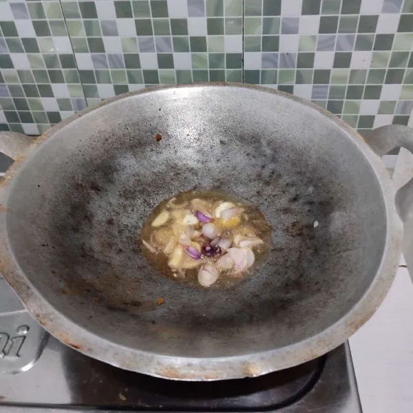 Tumis bawang merah dan bawang putih dengan sedikit minyak goreng sisa menggoreng ikan peda. Tumis hingga wangi.