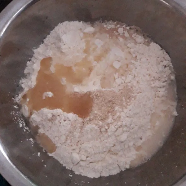 Buat bahan doughnya terlebih dulu. Campurkan tepung terigu, ragi instan dan gula pasir. Tambahkan air sedikit demi sedikit sambil diuleni sampai setengah kalis.