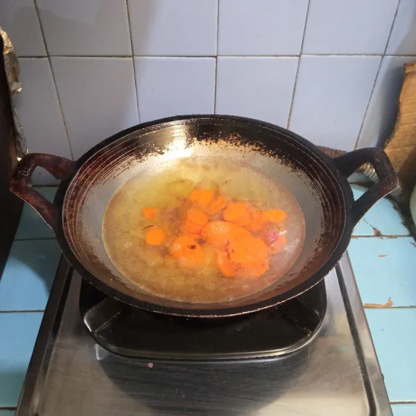 Masukkan wortel, lalu tuang air, masak hingga mendidih dan wortel setengah matang.
