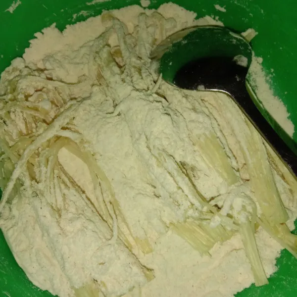 Masukkan jamur enoki dalam wadah tepung, lalu baluri/aduk agar semua terselimuti oleh tepung.