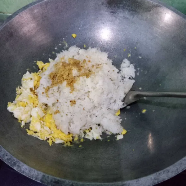 Masukkan nasi dan bumbu nasi goreng. Aduk-aduk hingga tercampur rata.