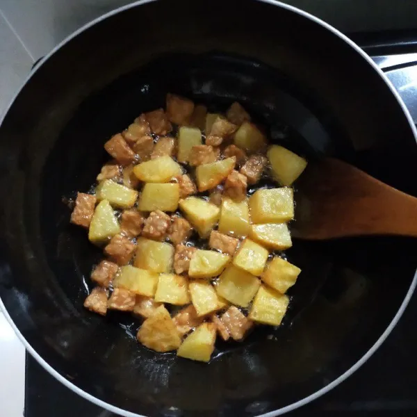 Goreng kentang dan tempe hingga kuning kecokelatan, lalu angkat dan tiriskan.