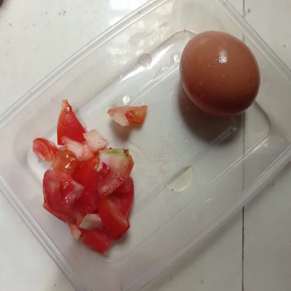 Siapkan telur dan tomat, lalu potong tomat kotak kecil.