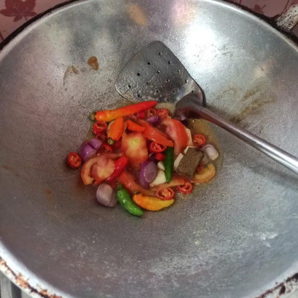 Goreng bahan sambal bawang merah, bawang putih, cabai, tomat dan terasi hingga matang.