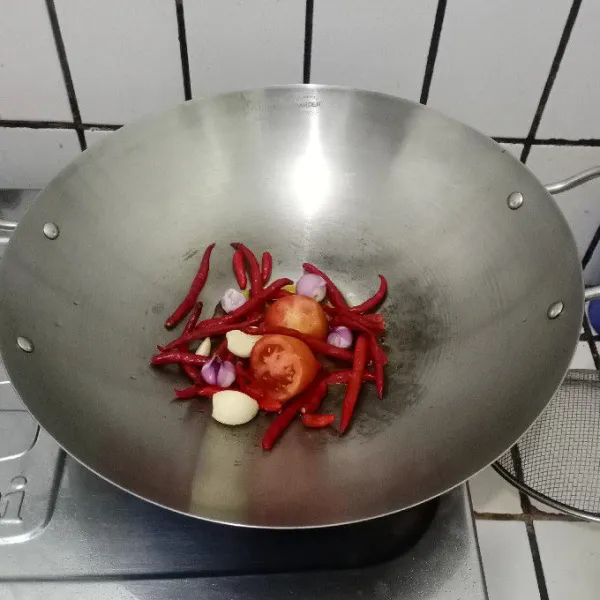 Goreng cabe rawit merah, cabe merah, tomat, bawang merah, bawang putih & terasi dengan minyak hingga lunak