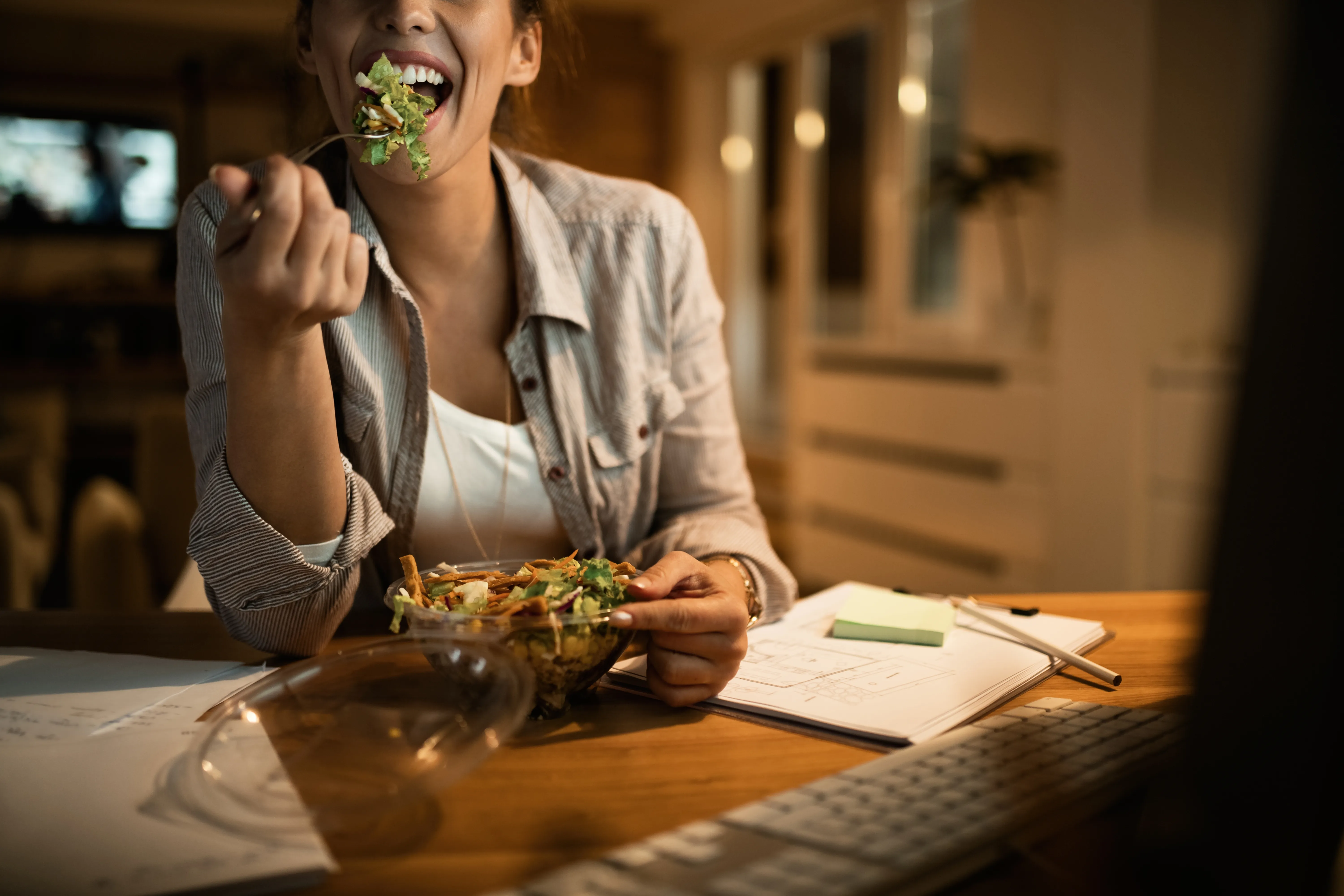 Seorang perempuan sedang makan sayur