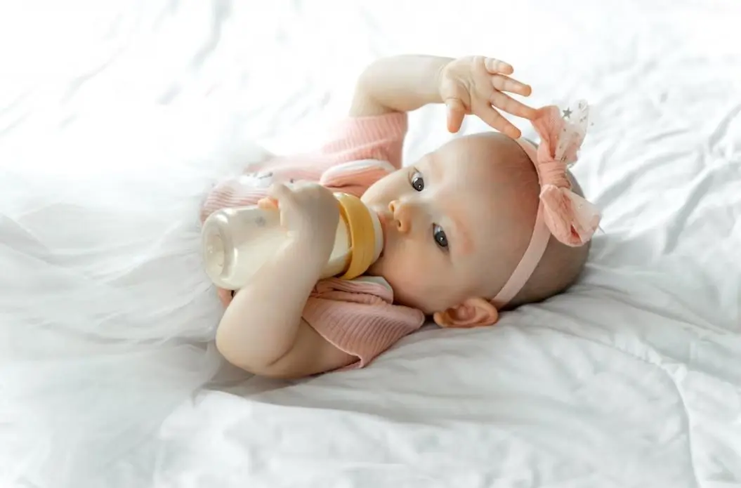 ilustrasi bayi yang sedang minum susu dari botol