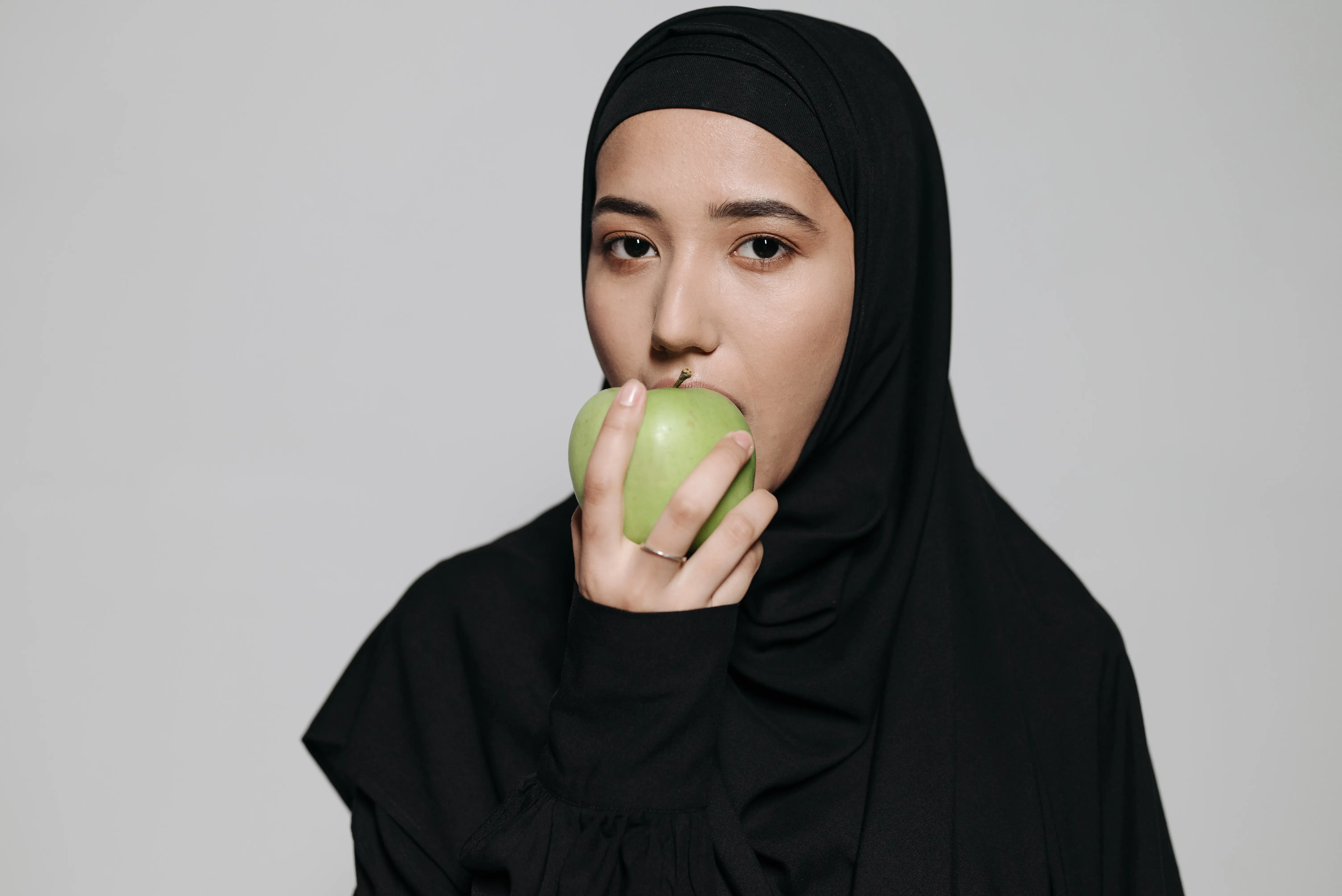Seorang wanita makan buah apel dengan perlahan