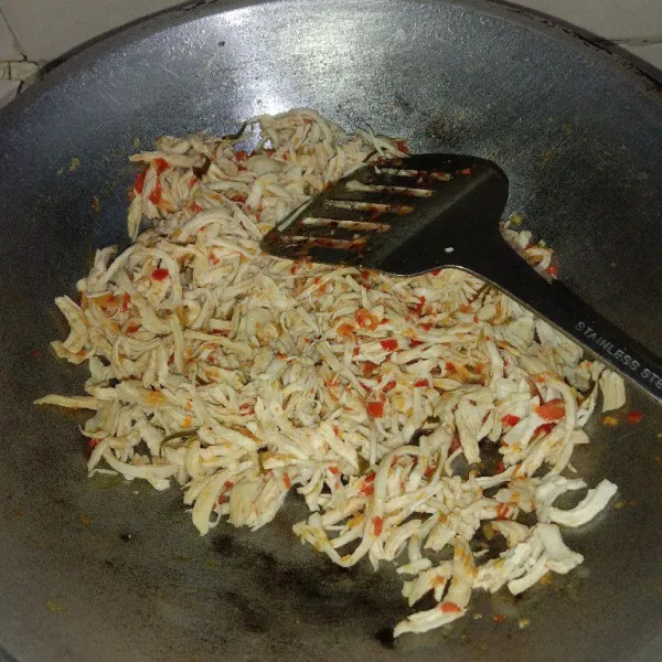 Tuang ayam yang sudah disuwir, masak sampai bumbu matang dan ayam sedikit kering.