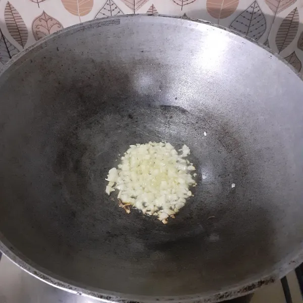 Tumis bawang putih hingga harum.