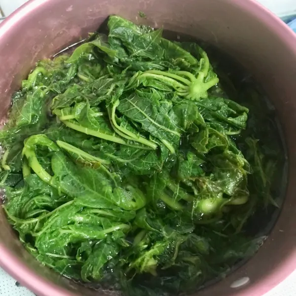 Rebus kembali daun dengan air garam dan asam jawa selama 3 menit. Kemudian bilas ulang dengan air mengalir dan remas daun (di akhir keringkan daun dengan meremasnya agak tak ada air yang tersisa di daun). Lalu potong-potong daun pepaya.