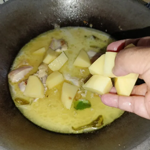 Masukkan santan encer dan kentang, masak sampai ayam dan kentang matang.