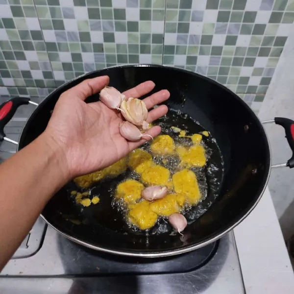 Jika sudah setengah matang, masukkan bawang putih. Masak kembali hingga berwarna golden brown dan ayam garing, kemudian angkat dan tiriskan minyaknya.
