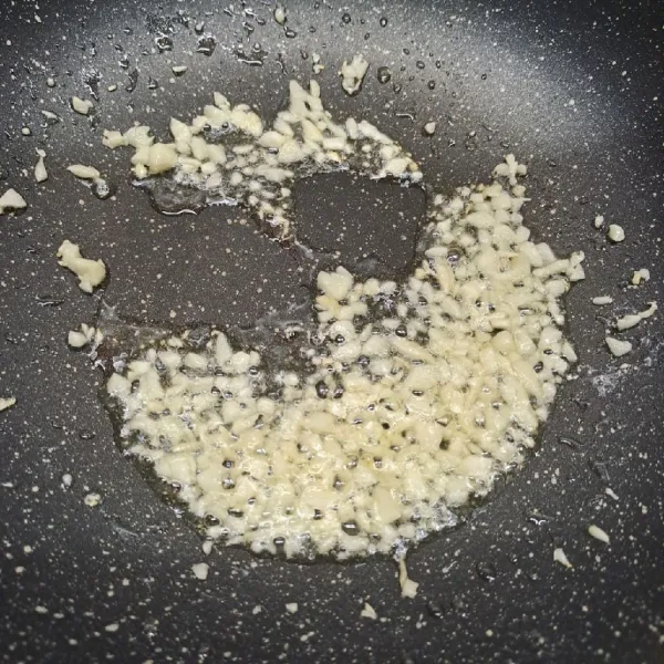 Tumis bawang putih cincang sampai layu dan harum.