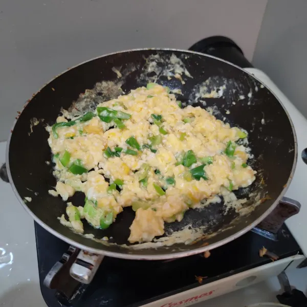 Kocok lepas telur, beri irisan daun bawang dan kaldu jamur, kemudian orak-arik di pan anti lengket.