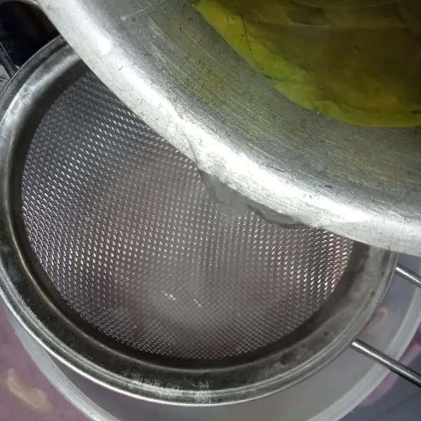 Saring air rebusan daun salam kedalam gelas.