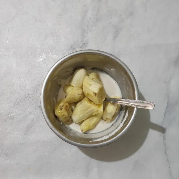 Masukkan potongan pisang ke dalam adonan basah.