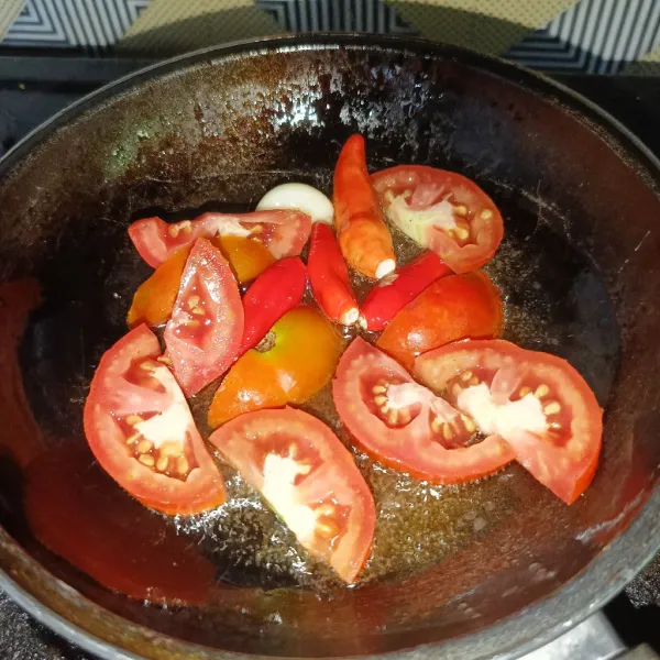 Goreng cabai rawit, bawang putih dan tomat sampai layu.