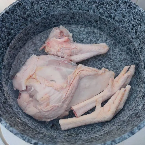 Rebus ayam hingga mendidih, buang airnya dan cuci bersih kembali. Kemudian rebus kembali ayam hingga empuk dengan api kecil.