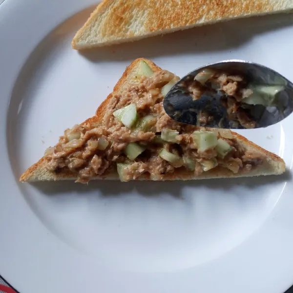 Siapkan roti tawar panggang, potong diagonal. Tata ikan tuna mayo di atas roti, tangkupkan. Sajikan sebagai sarapan atau isian kotak bekal.