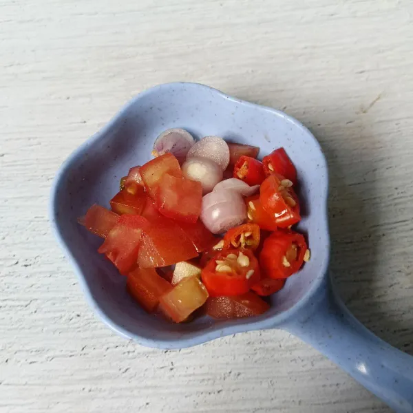 Potong-potong cabai rawit, tomat merah dan bawang merah.