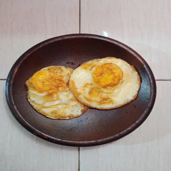 Ambil piring, tata telur kemudian siram dengan sambal.