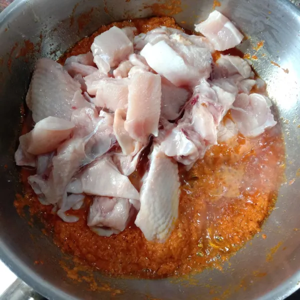 Masukkan potongan ayam. Aduk rata. Masak sampai daging ayam berubah warna.