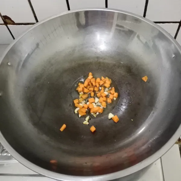 Tumis bawang putih hingga harum. Tambahkan wortel. Masak hingga layu