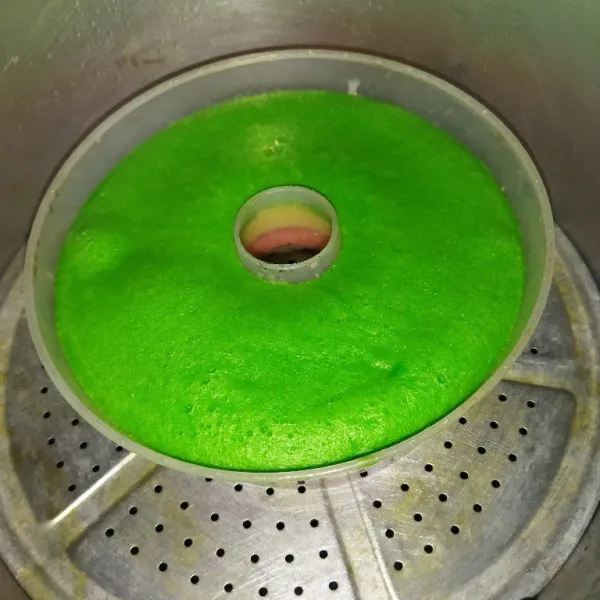 Sisa 1 bagian adonan diberi pasta pandan, lalu tuang adonan hijau di atas adonan putih, kukus selama 15 menit, lalu angkat.