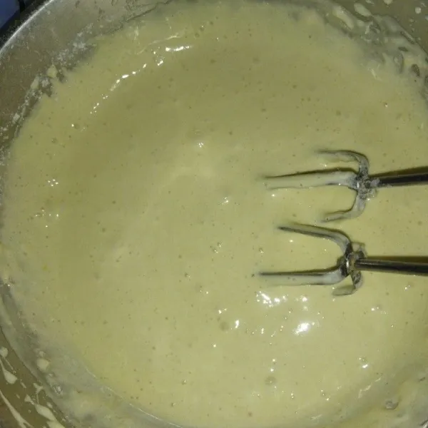 Lalu masukkan tepung terigu sambil diayak, baking powder, vanili bubuk, mixer dengan kecepatan rendah, tambahkan krimer kental manis dan santan sedikit demi sedikit, mixer hingga tercampur rata.