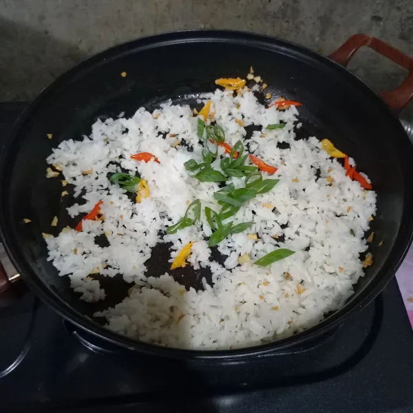 Masukkan nasi, daun bawang, garam dan penyedap.