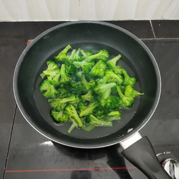 Potong brokoli per kuntum. Lalu rebus dalam air mendidih sebentar saja, cukup hingga brokoli berubah warna. Lalu angkat dan tiriskan.
