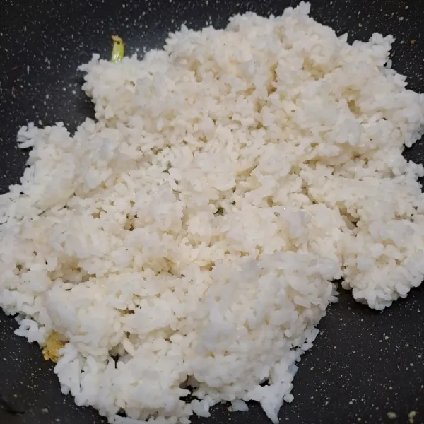 Masukkan nasi putih, aduk rata dengan tumisan.