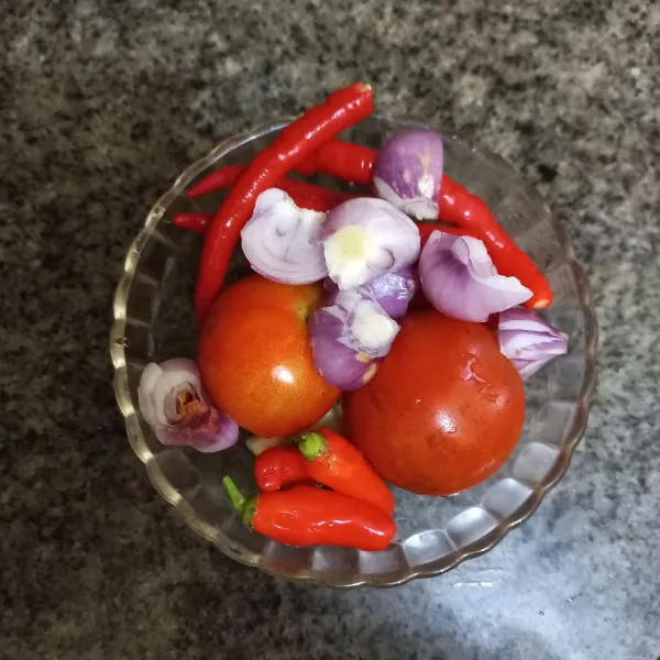 Haluskan bawang merah, bawang putih, tomat, cabe rawit dan cabe merah keriting.