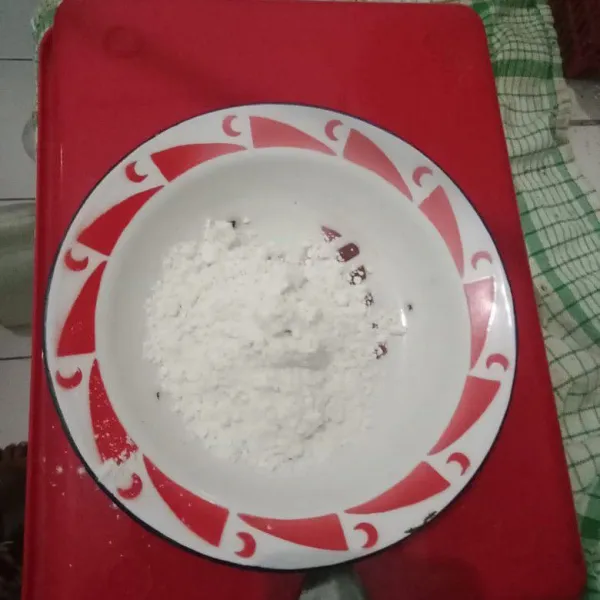Tuang tepung terigu dalam piring.