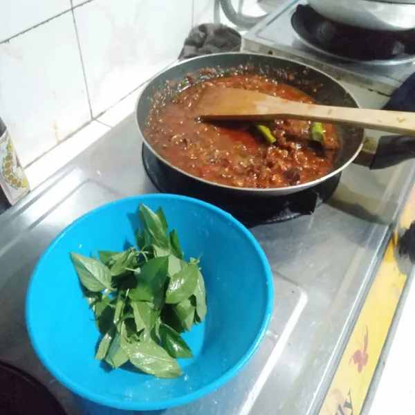 Masukkan daun kemangi yang sudah dicuci bersih, aduk hingga rata, koreksi rasa, jika sudah pas matikan kompor dan sajikan di piring saji.
