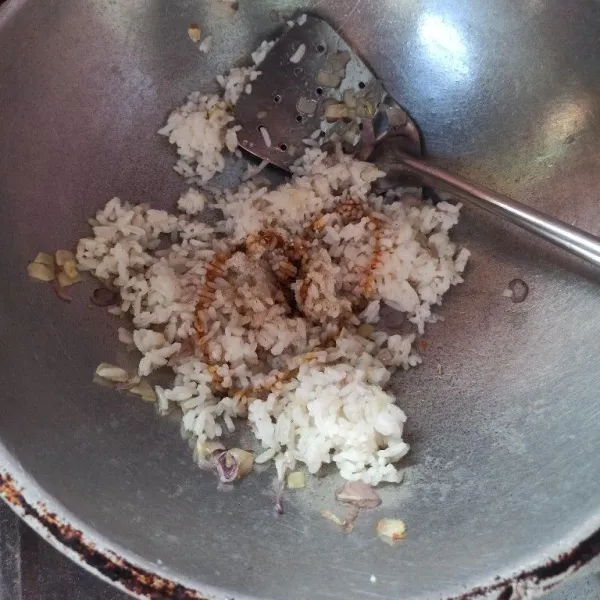 Selanjutnya masukkan nasi, aduk rata. Lalu masukkan garam, kaldu jamur dan kecap manis, aduk hingga rata.