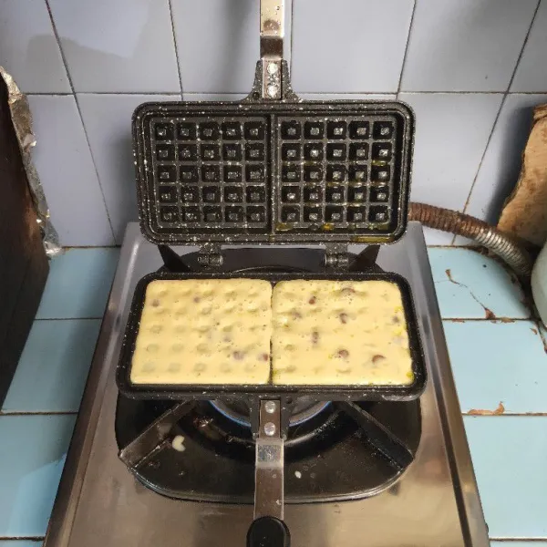 Panaskan cetakan waffle, kemudian olesi dengan sedikit margarin. Tuang 2 sdm adonan dan biarkan hingga bergelembung. Lalu tutup cetakan dan gunakan api kecil.