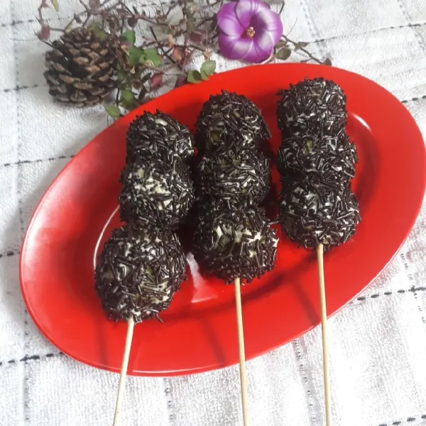 Setelah dingin, tusuk donat dengan tusuk sate, olesi butter cream dan taburi meses.