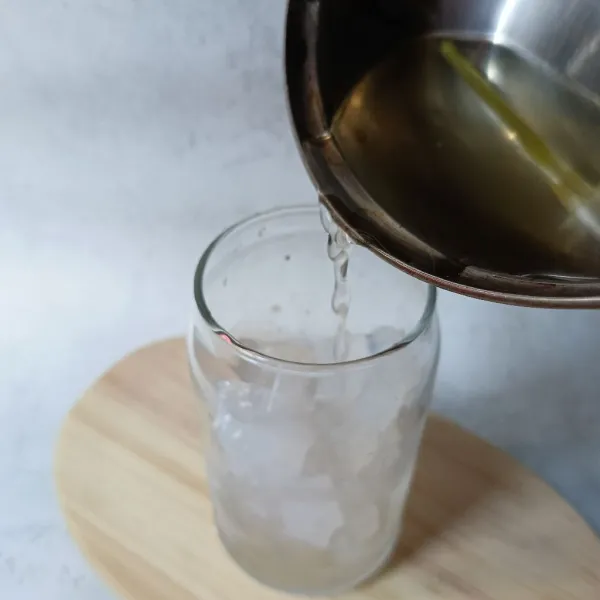 Tuang air rebusan serai ke dalam gelas.