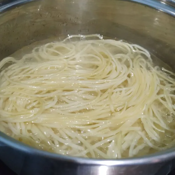 Didihkan air, masukkan 1 sendok makan olive oil dan spaghetti. Rebus spaghetti hingga aldente lalu tiriskan.