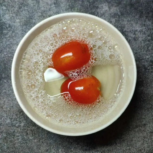 Cuci bersih tomat menggunakan cairan pencuci buah dan sayur, kemudian bilas kembali hingga bersih.
